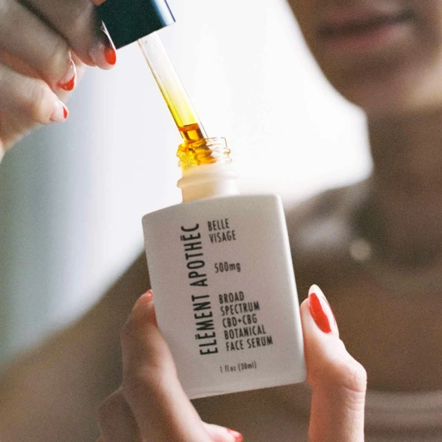 a close up of someone holding a small bottle