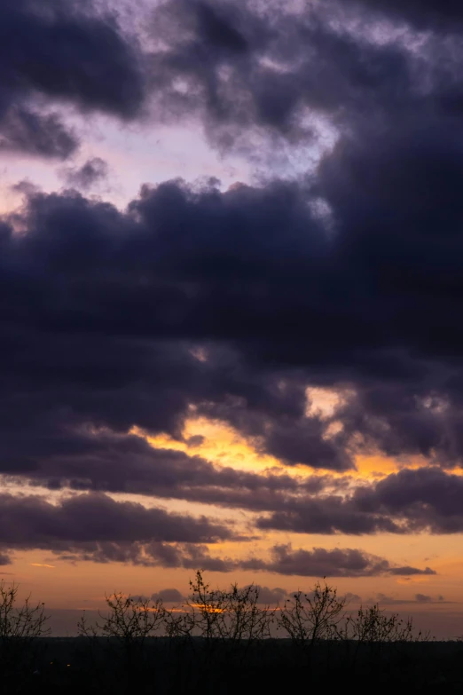 the sky is filled with dark clouds during sunset