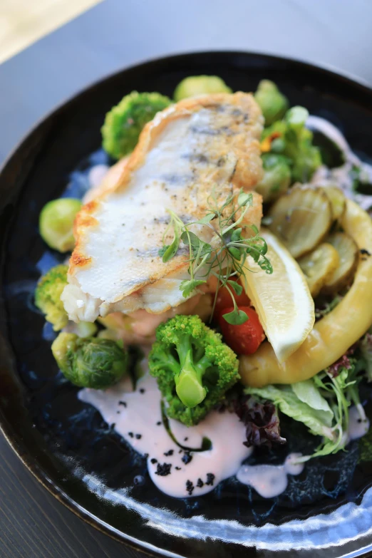 an image of fish with potatoes and broccoli