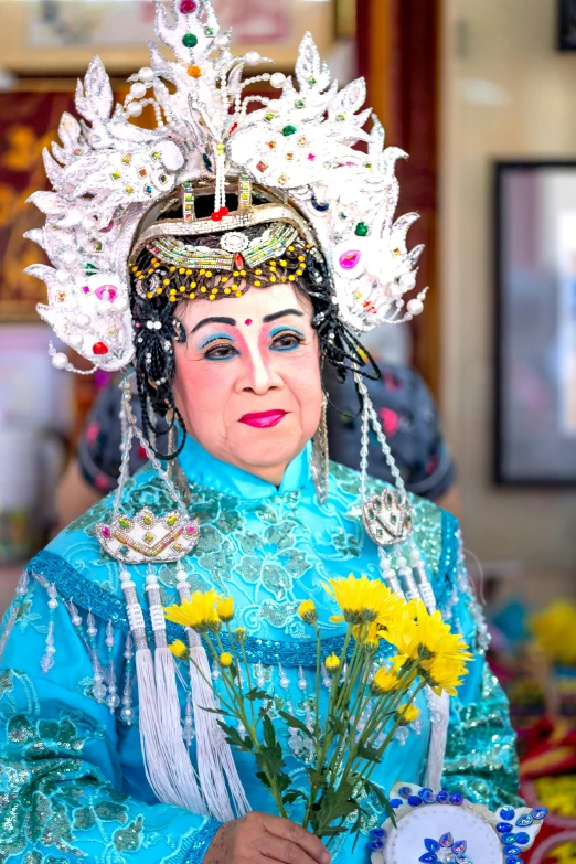 a woman in oriental costume holding flowers