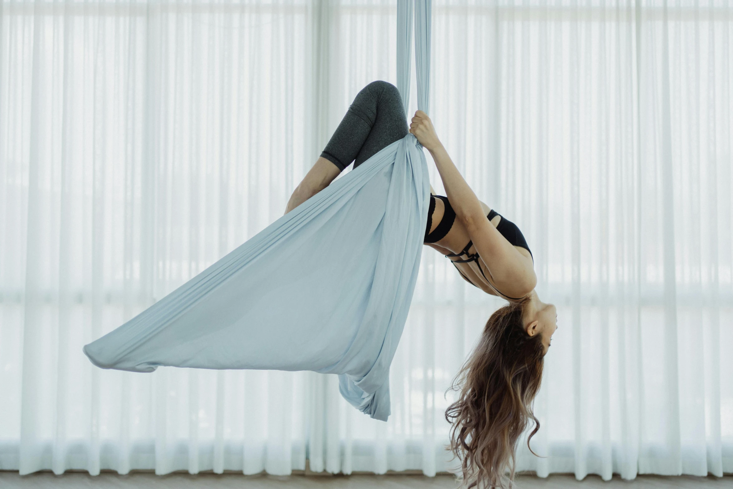 the woman is standing on one leg, in a hammock