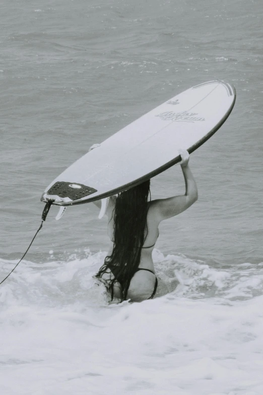 a person in a bikini holding up a surfboard