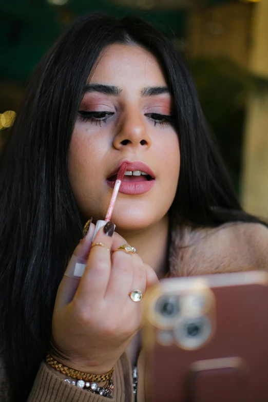 a woman that is smoking a cigarette while using a cellphone