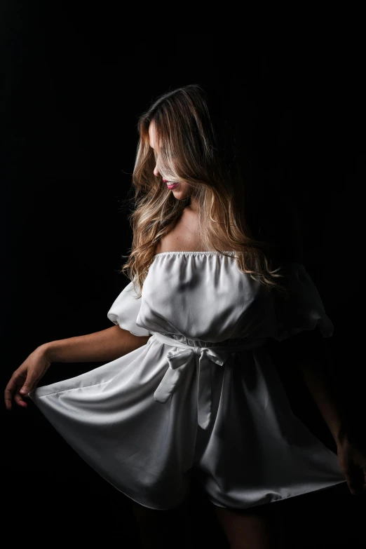 a woman standing in the shadows wearing a white dress