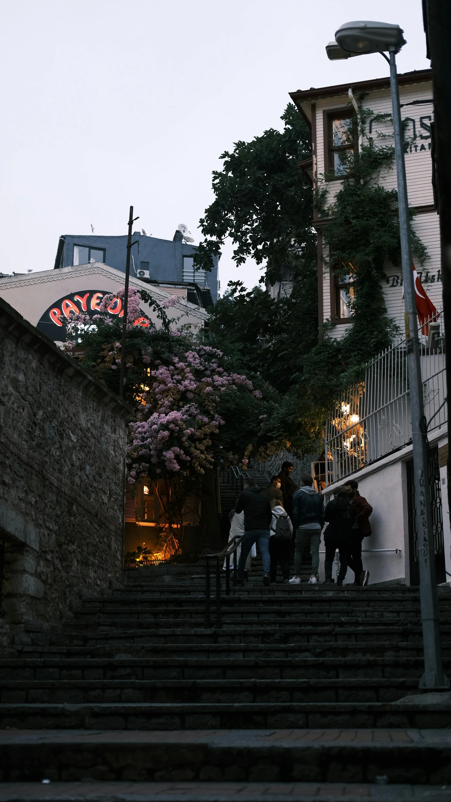 a group of people walk up the stairs in front of a building