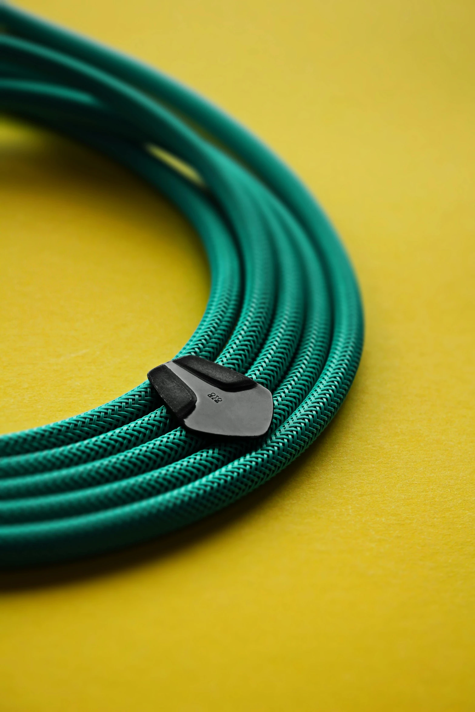 a green coiled cable with a black plastic on on it