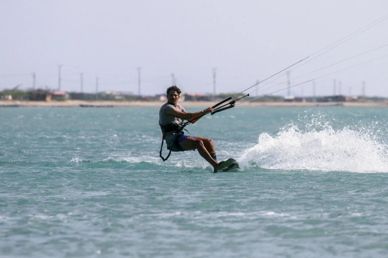 a man is on the water holding onto a kite