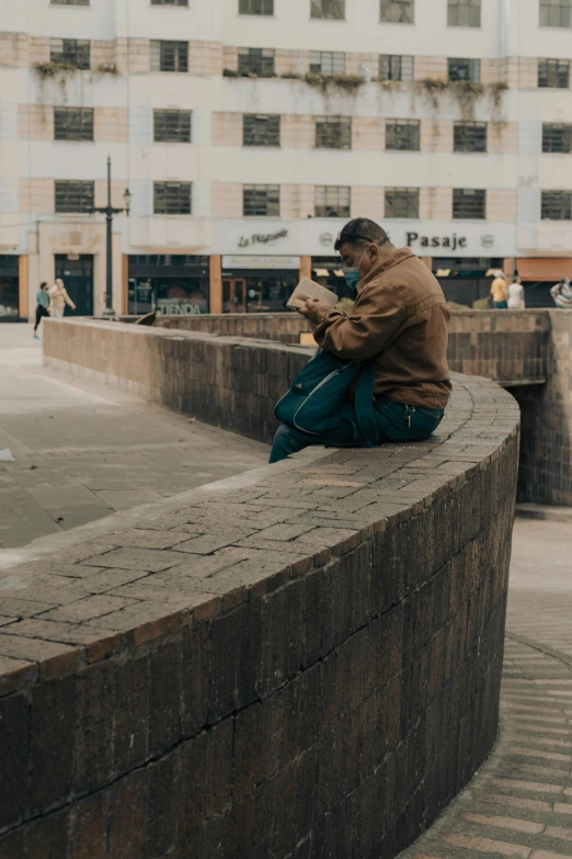 a man sitting on the curb with a cell phone