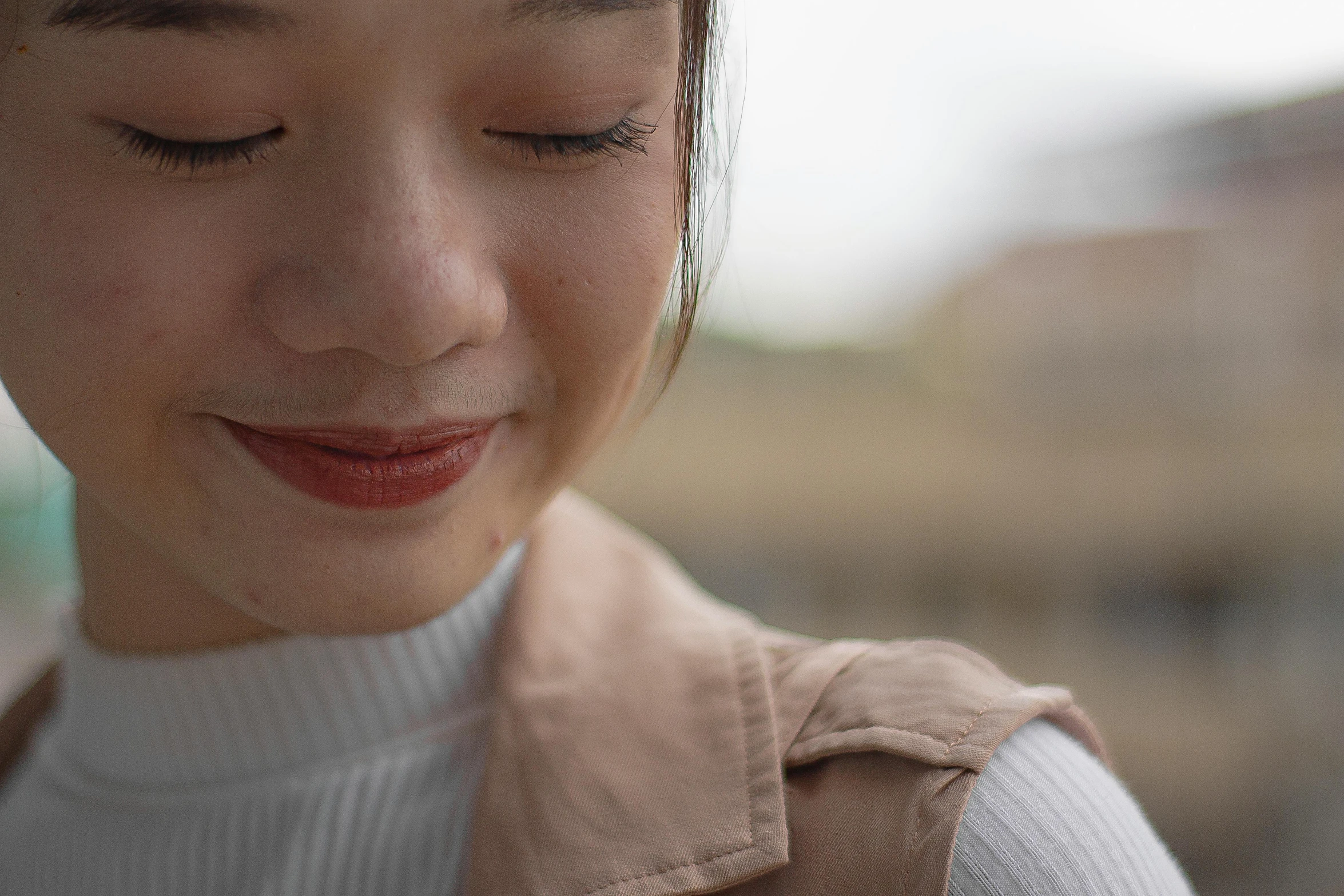 a woman smiles while looking at her cell phone