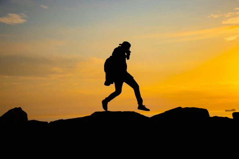 a man running down a mountain with a back pack