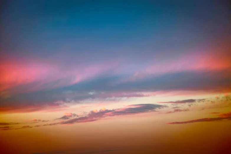 the sky is cloudy with pink and blue clouds