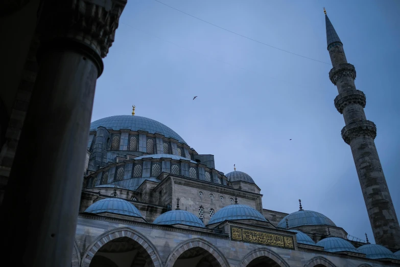 a gray dome and blue dome building in a cloudy day