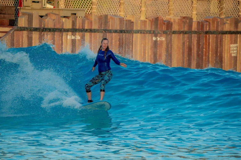 a woman surfing in an indoor wave pool