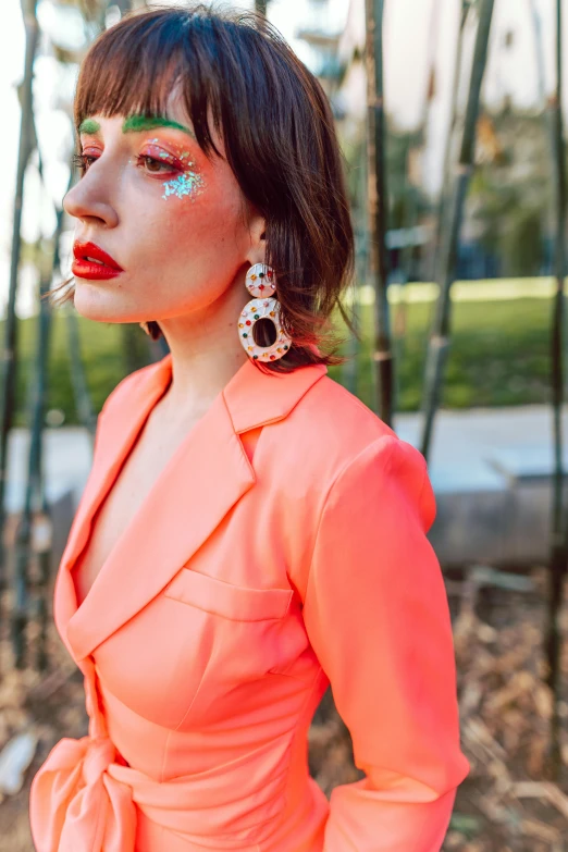 a young woman in a bright dress and earrings