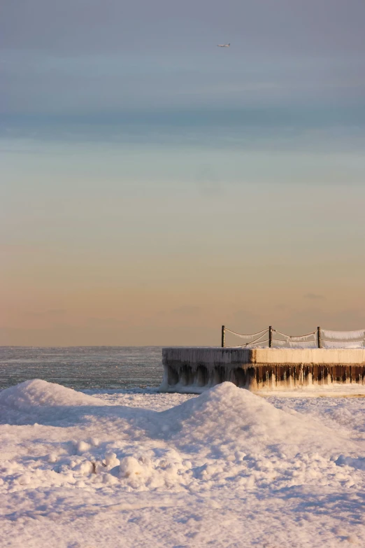 snow covered ground near a pier in a small town