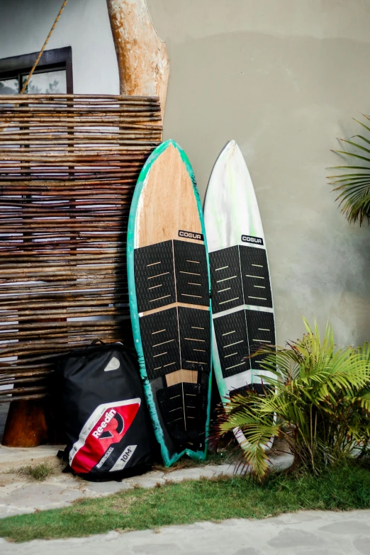 two surfboards are leaning up against a wall