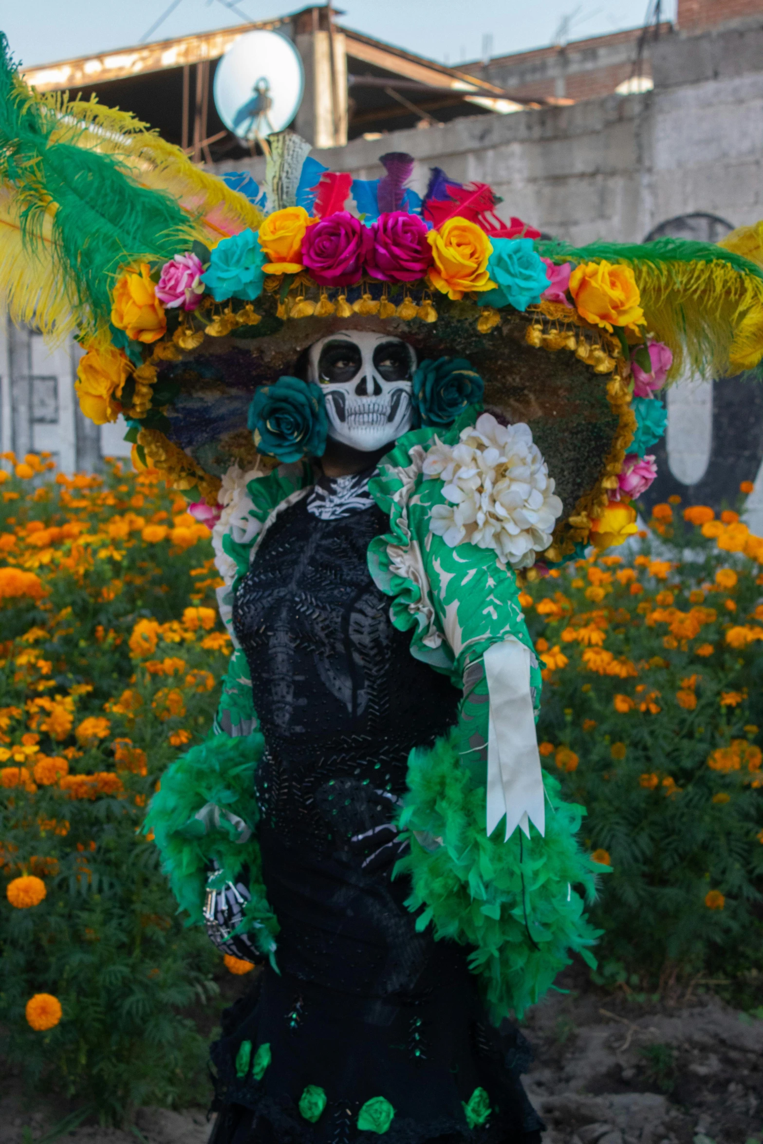 a woman in a mexican dress and floral decorations, standing in front of flowers