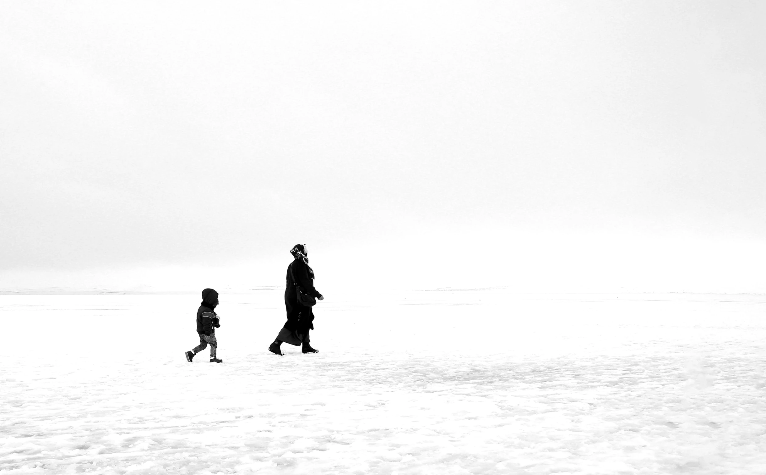 a man walking with his child through snow