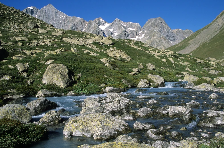 a stream is running between some very rocky mountains
