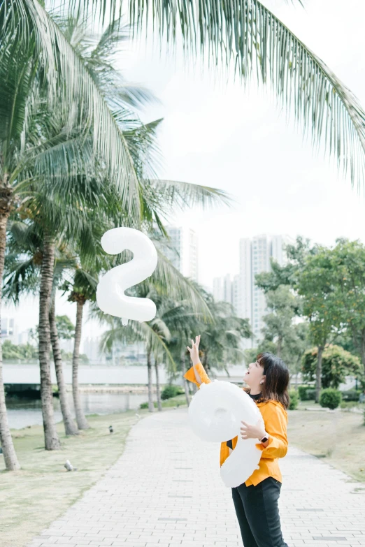 a woman throwing white balloons in the air