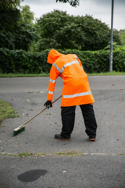 a person in a safety jacket is cleaning the street