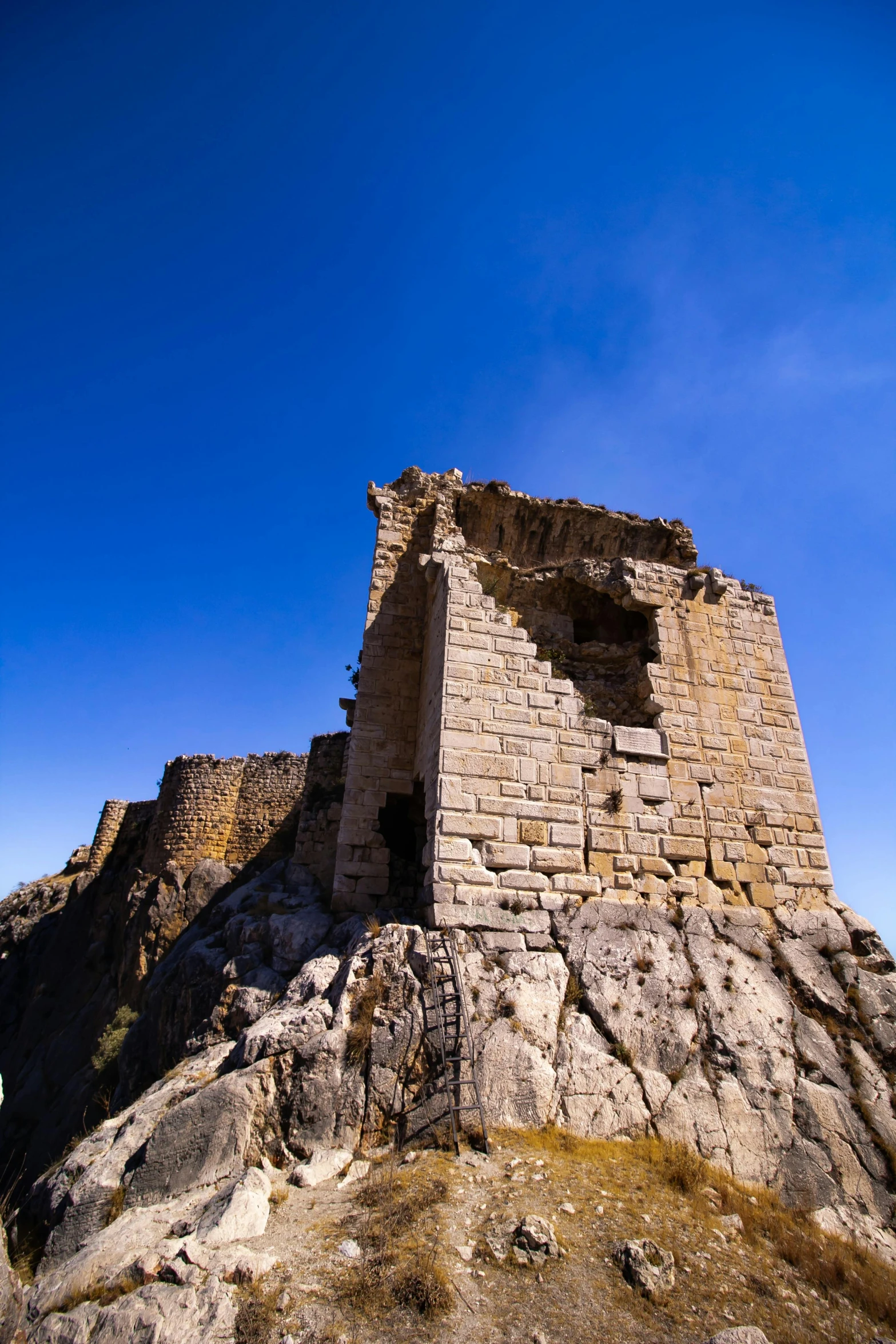 a very tall and pretty brick castle on the side of a hill