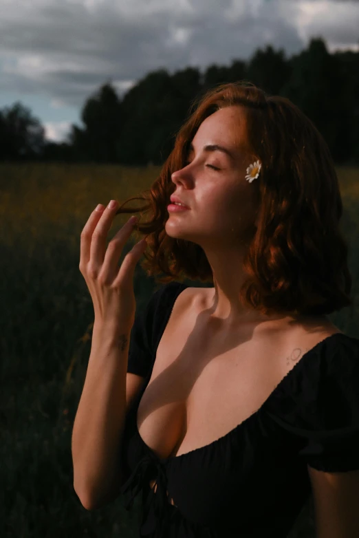 a woman is smoking a cigarette on a field