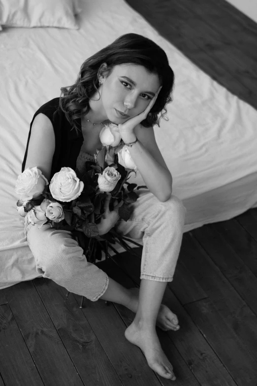 the woman is sitting on the floor with flowers in her hands