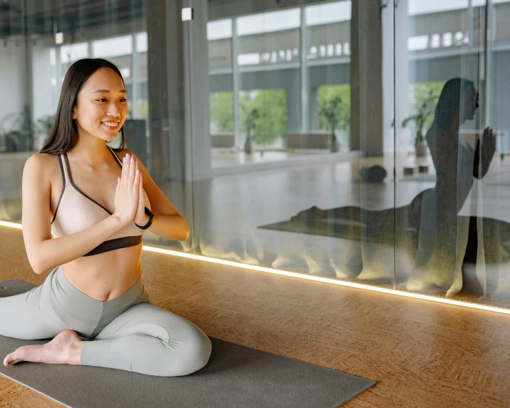 a smiling woman meditating in a yoga pose