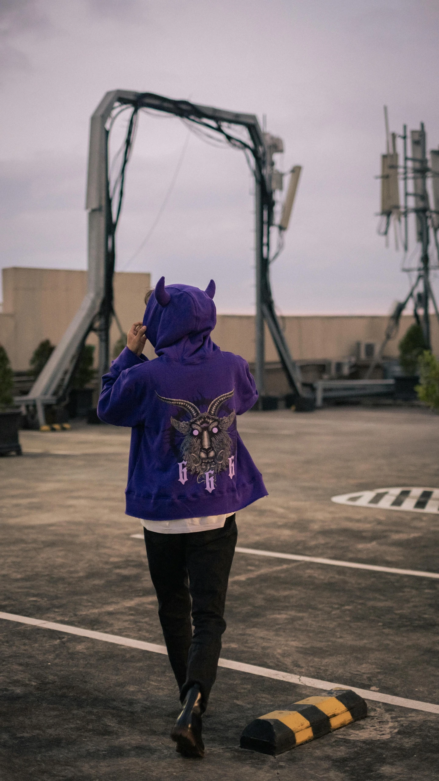 a person walking by a building wearing a purple jacket