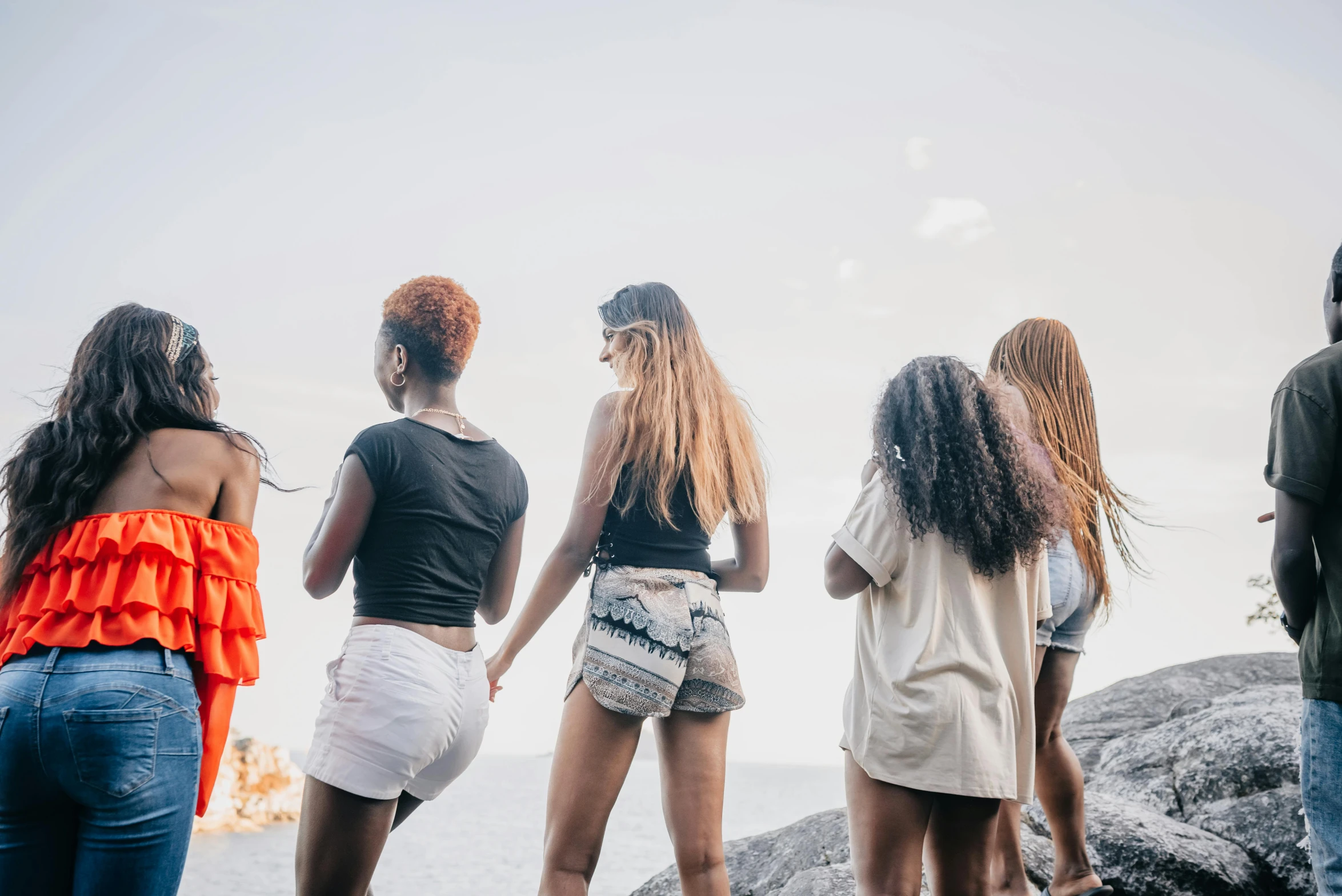 five women stand at the edge of the water