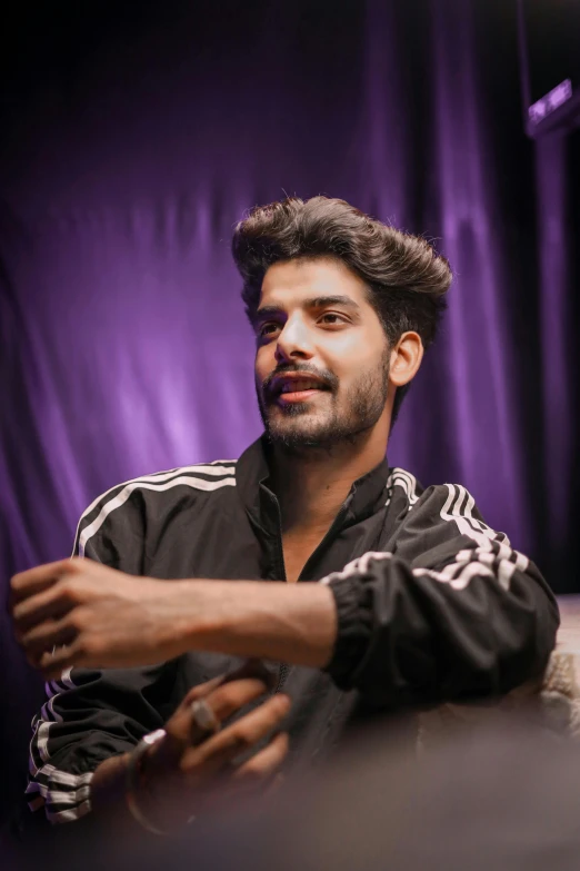 an indian man sitting in front of a laptop