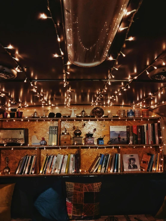 lights shining down over a bookshelf filled with books