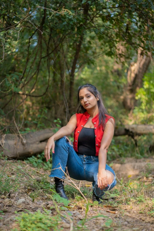 a woman sitting on the ground posing for the camera