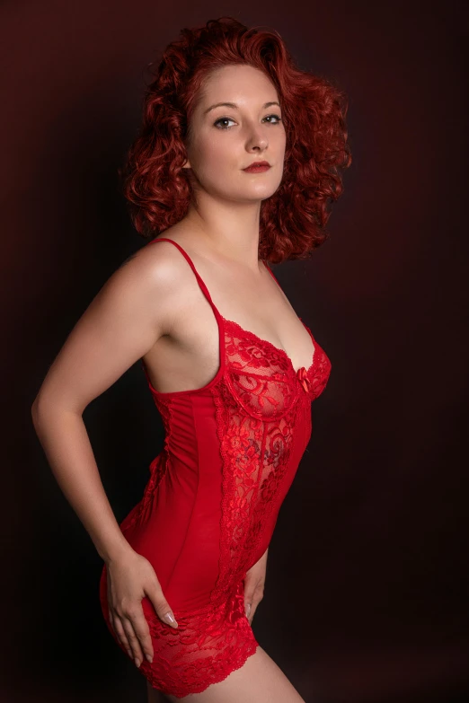 a young red - headed woman wears a  bodysuit and poses for a pograph