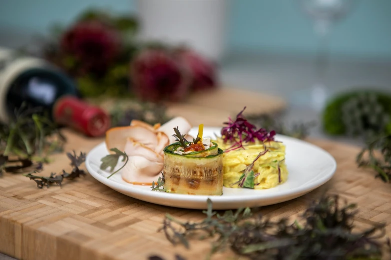 small food item on white plate next to bottle of wine