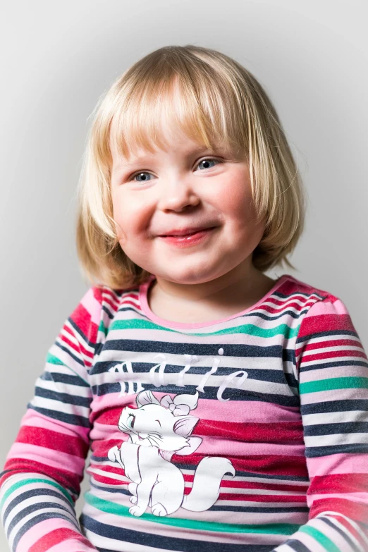 a close up of a child with blonde hair wearing a shirt