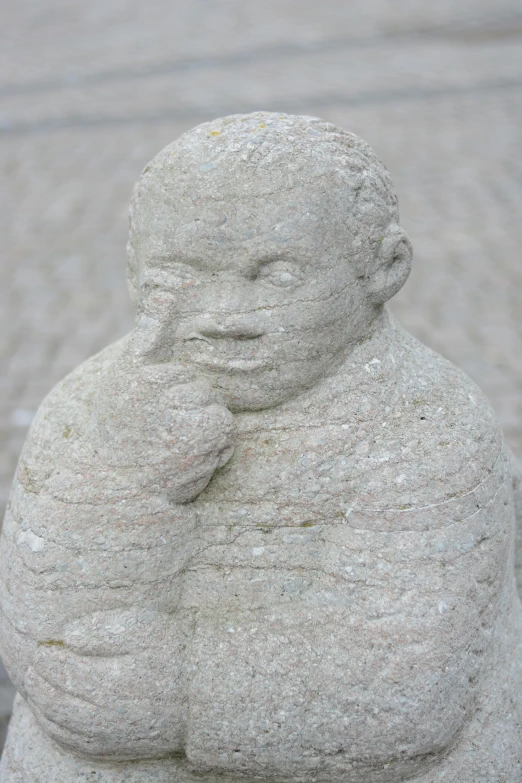 an interesting sculpture on a cobble stone sidewalk