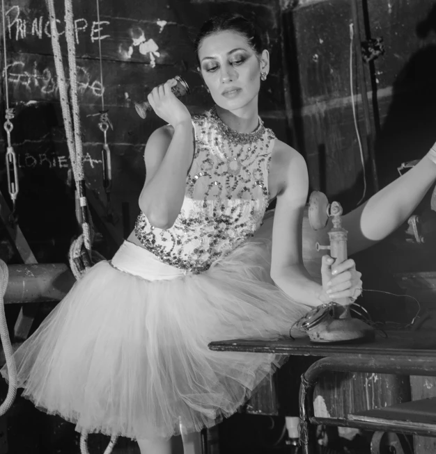 an attractive woman in an outfit leaning on a glass bottle