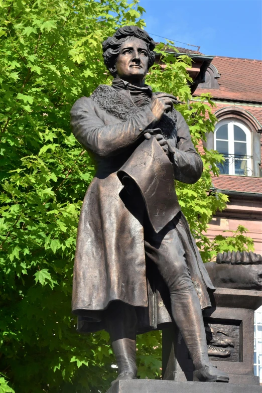 the bronze statue of a woman playing guitar outside a building