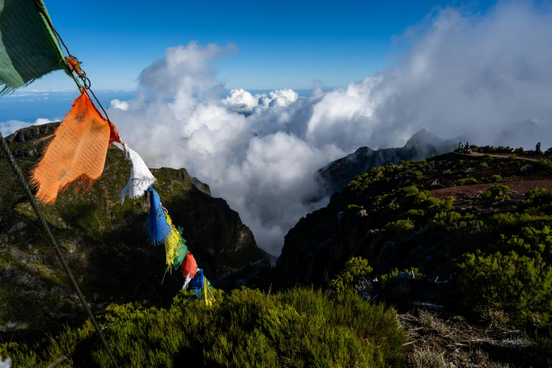 the mountain top covered in clouds and flying flags