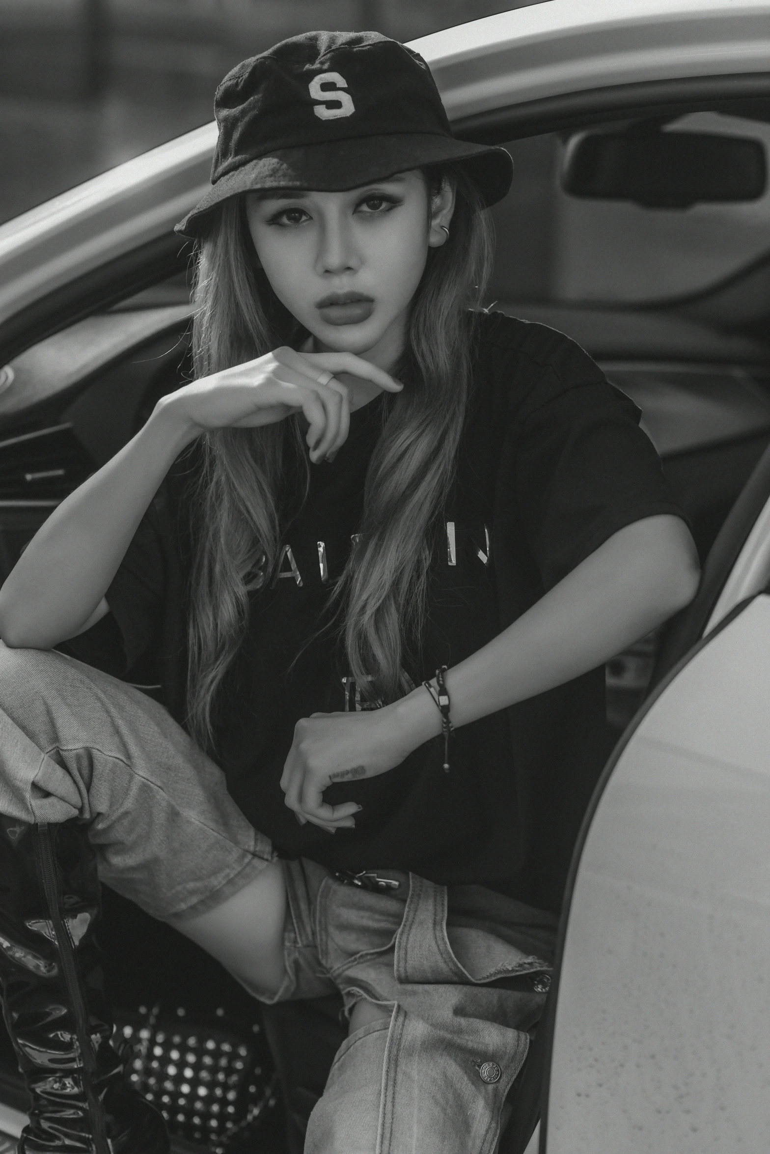 a girl leaning on the side of a car