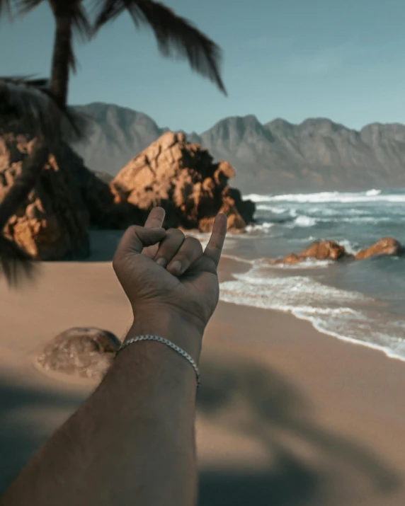 a person pointing a finger to the ocean and mountains