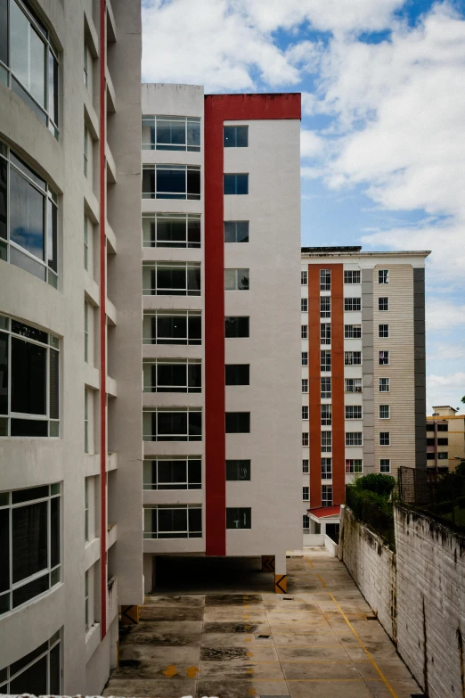 tall buildings, red and white, are against the blue sky