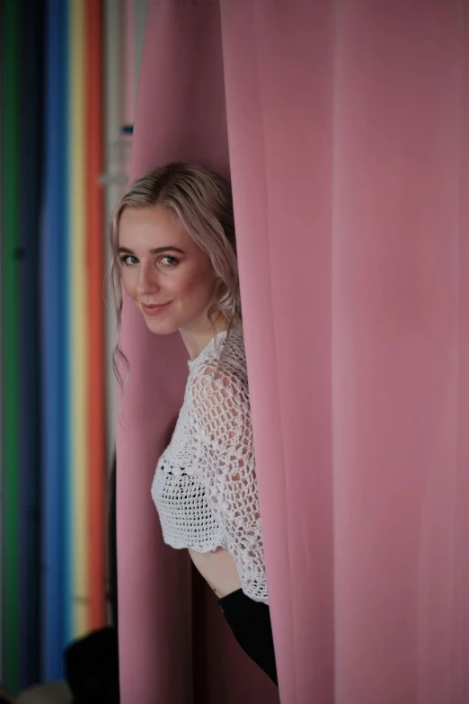 a woman peeking out from behind a column