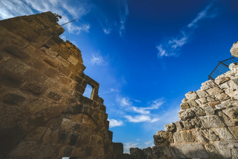 a ladder near a stone wall under a blue sky