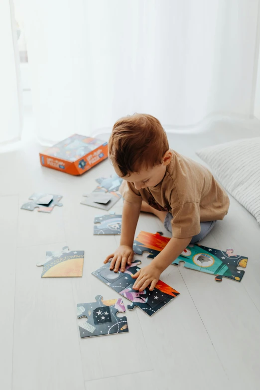 toddler playing with puzzles on the floor