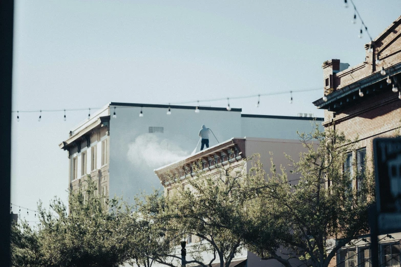 a city view from below a hill, with an apartment building and a white spray paint swirl in the background