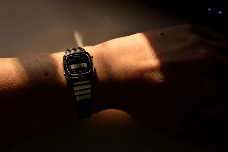 an old woman's wrist and watch on a dark background