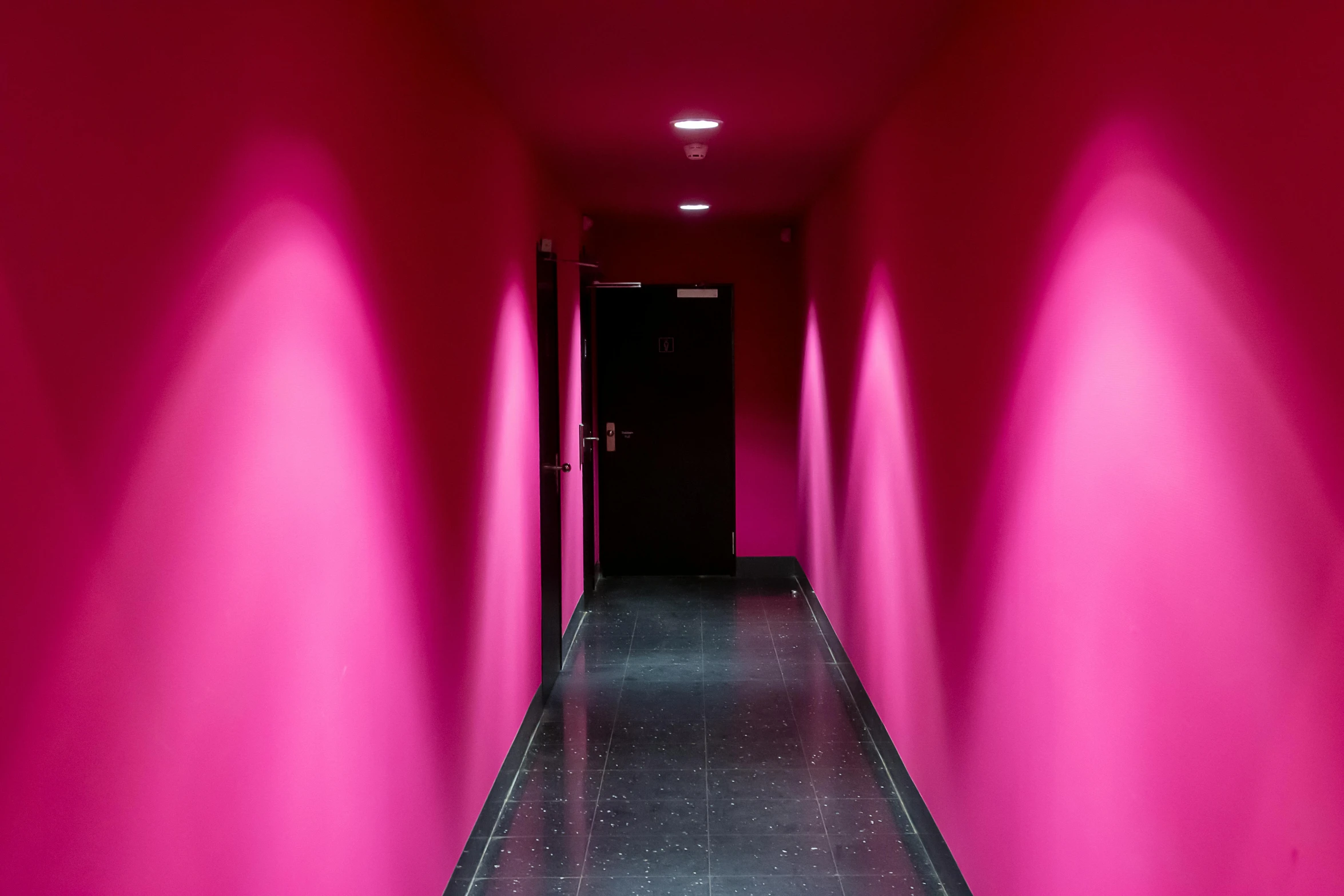 this is an hallway between two walls pink and black